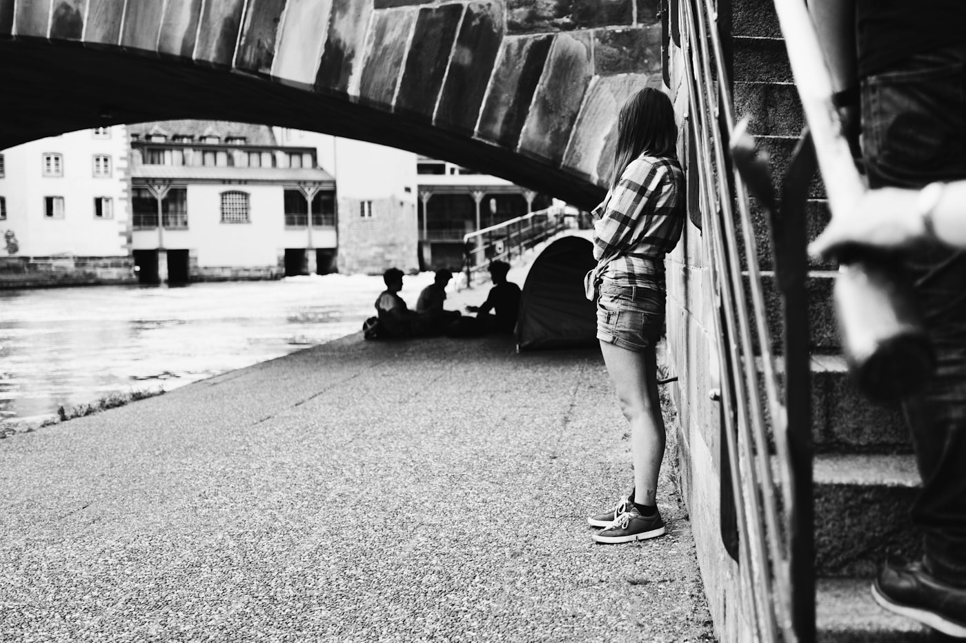 A figure leaning on concrete stairs, outdoors